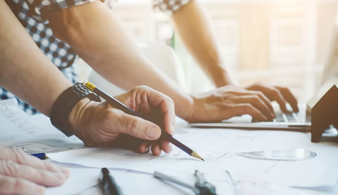 Designers reviewing architectural drawings at a desk