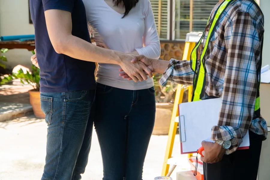 Homeowners greeting a construction consultant at their home