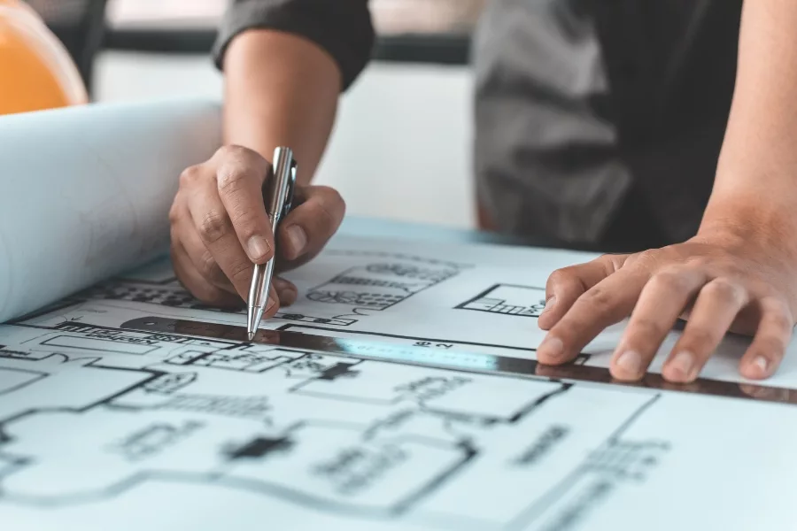 Designer measuring a floor plan with a scale ruler