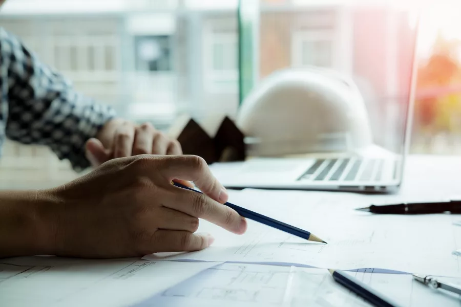 Designer marking construction plans at a desk